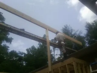 Carpenter setting a ridge beam over a new addition frame — Ice Dam Removal by Roofing Brothers in Wesley Chapel