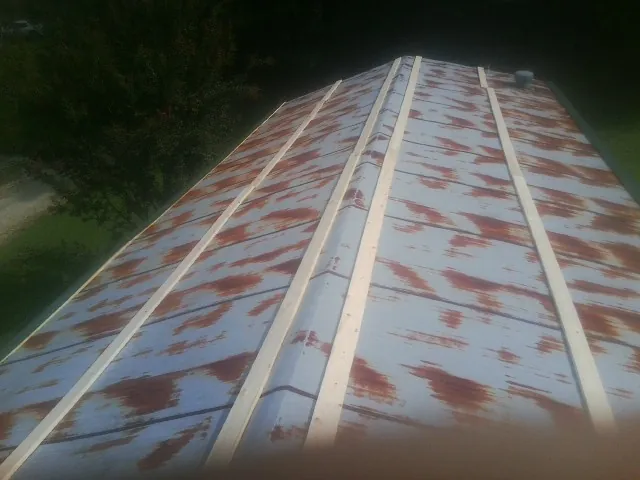 Rusted metal roof panels with new wood purlins before replacement — Storm Damage Roof Repair in Wesley Chapel by Roofing Brothers