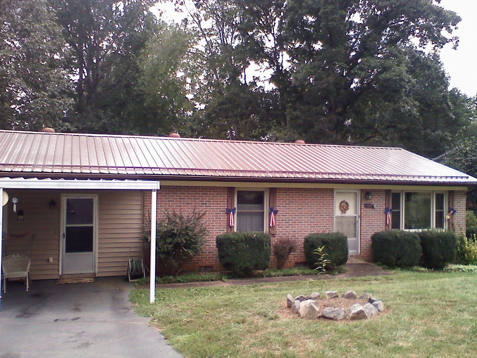 Bronze metal roof and carport on a brick ranch home — Roof Repair work by our crew in Wesley Chapel